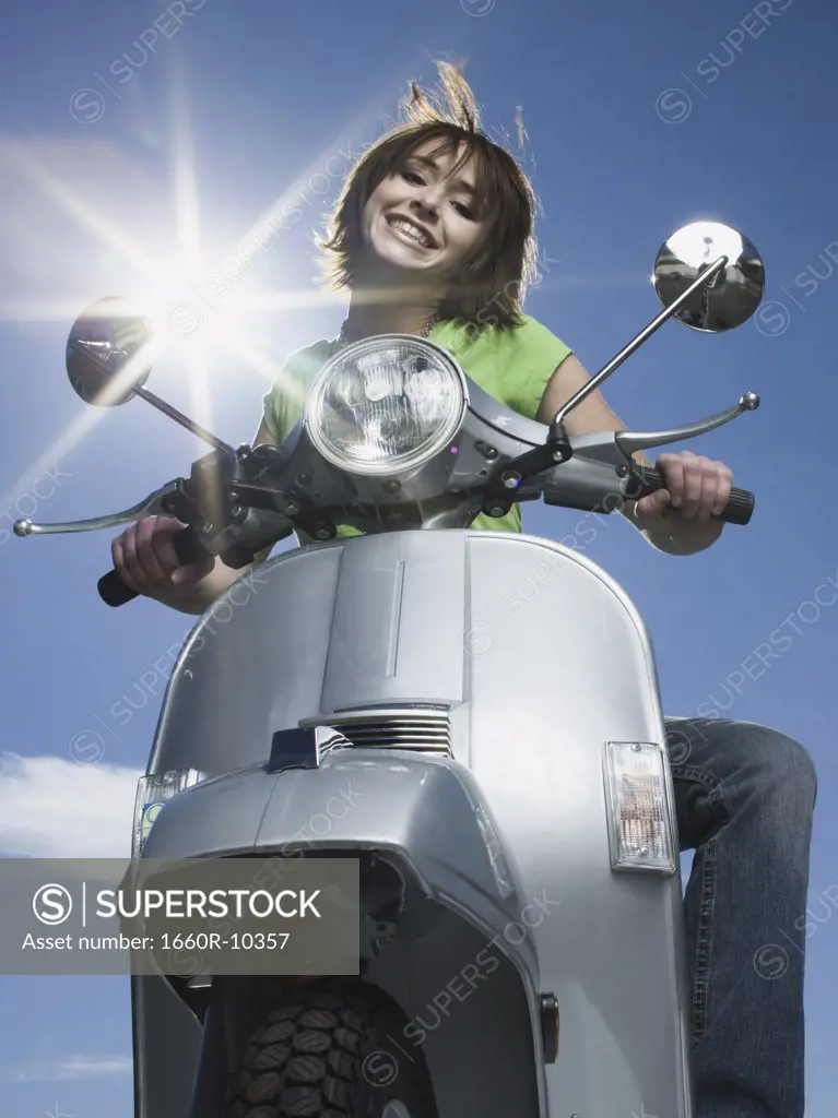 Low angle view of a teenage girl riding a scooter