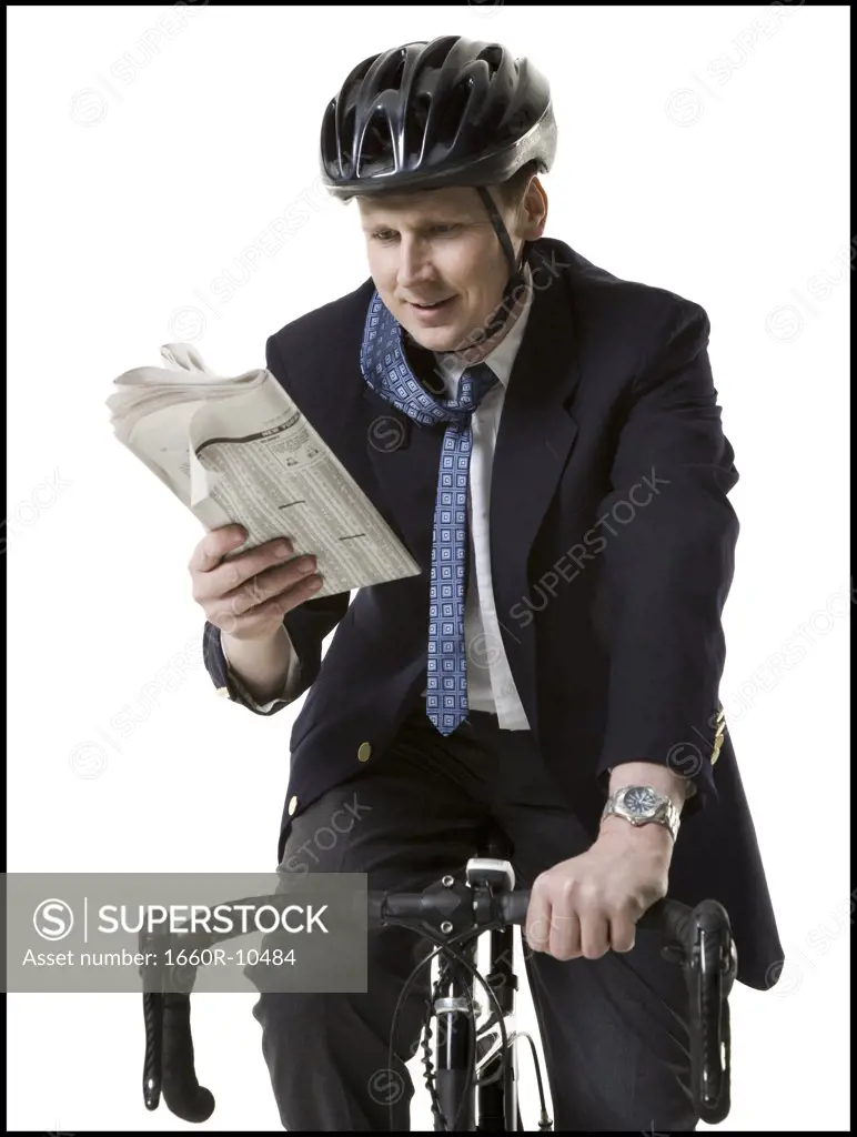 Close-up of a businessman reading a newspaper on a cycle