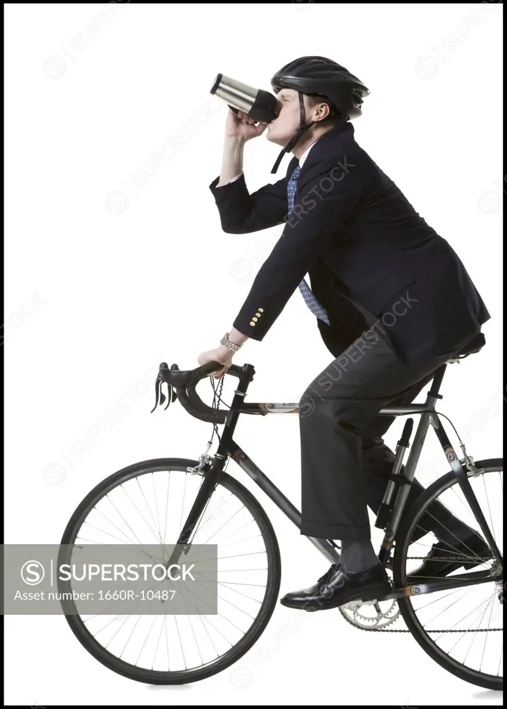 Profile of a businessman cycling and holding from a mug
