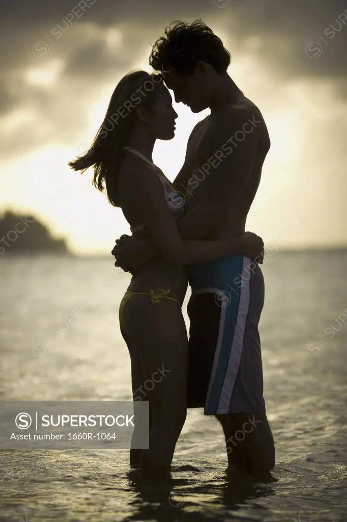Silhouette of a young couple embracing each other