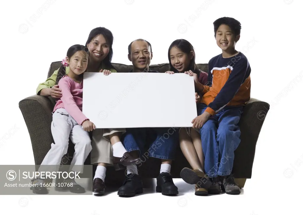 Portrait of a family holding a blank sign and smiling