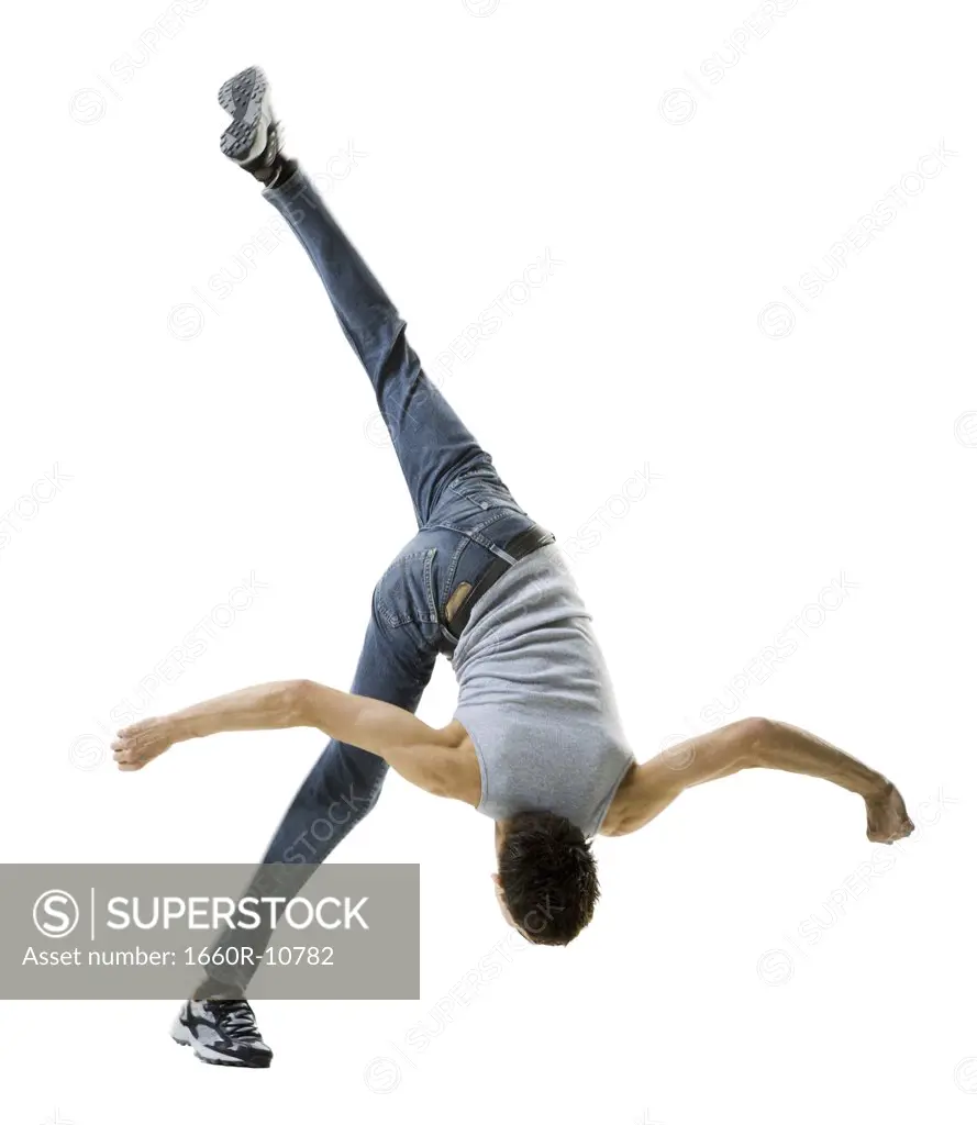 Rear view of a young man doing a back flip
