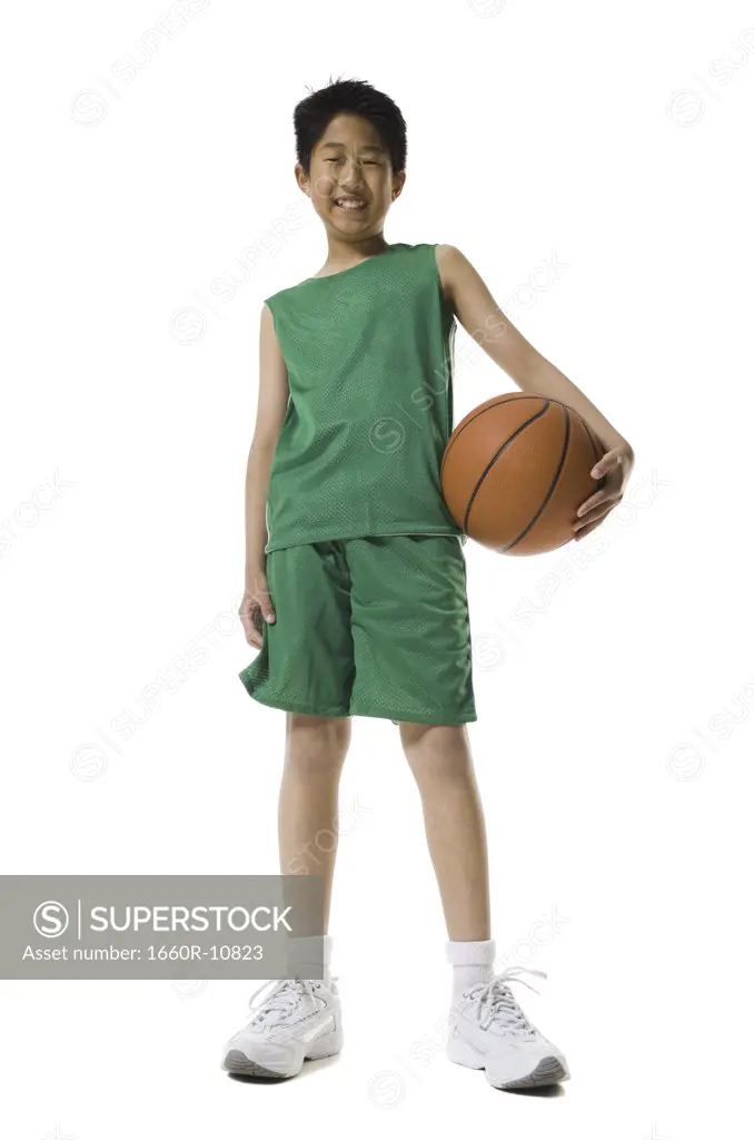 Portrait of a boy holding a basketball and smiling