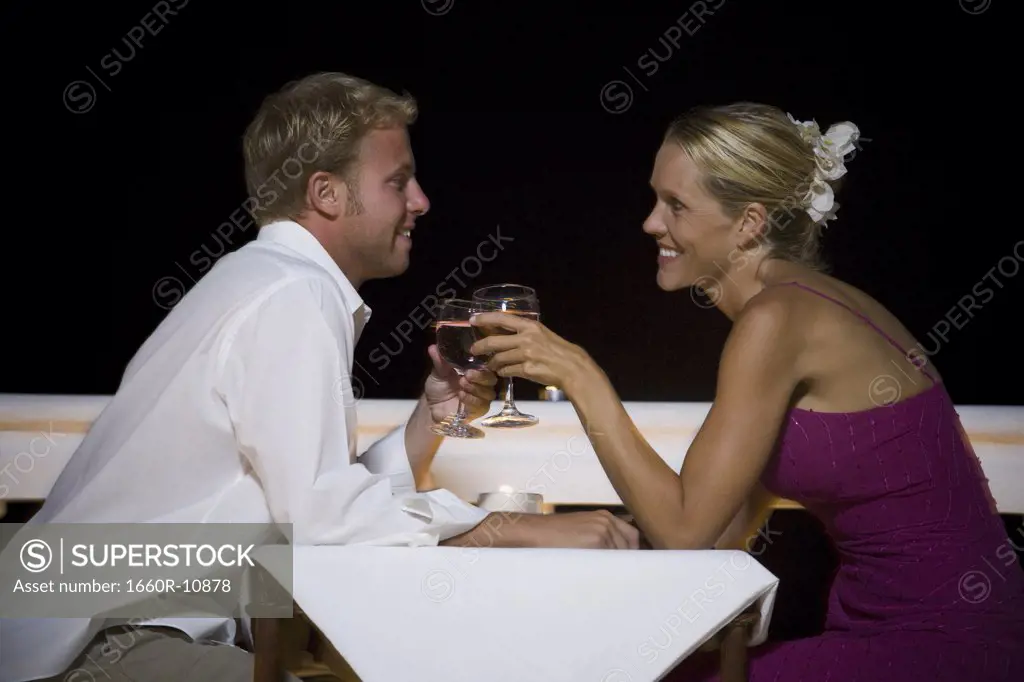 Profile of a man and a woman toasting with wineglasses