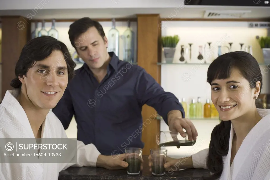 Bartender serving a young couple at a bar counter