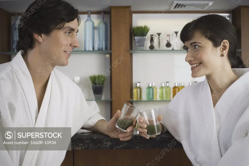 Close-up of a young couple holding glasses of wheatgrass juice