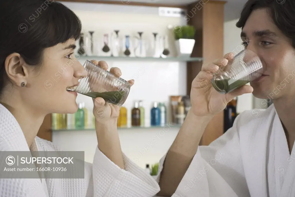 Close-up of a young couple drinking wheatgrass juice