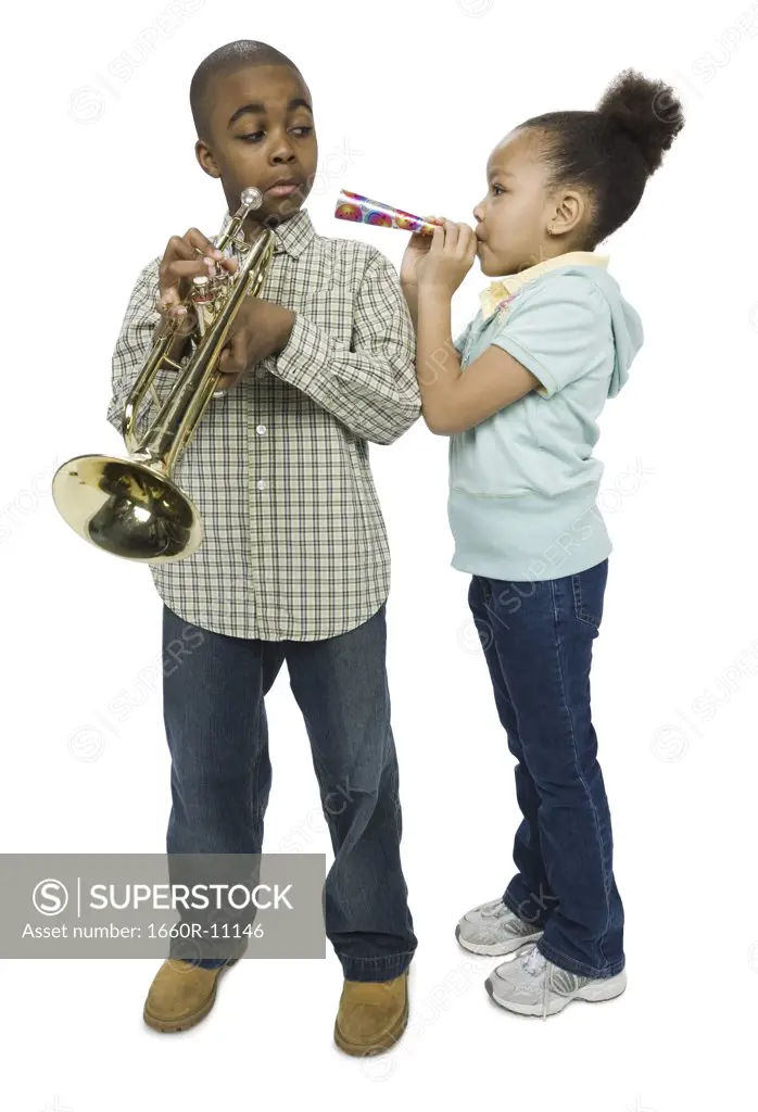 Boy looking at his sister blowing a party horn