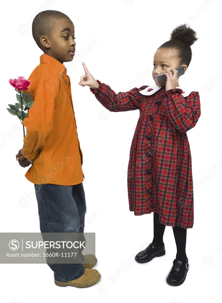 Profile of a boy looking at a girl talking on a mobile phone