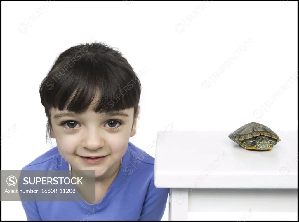 Portrait of a girl with a tortoise beside her
