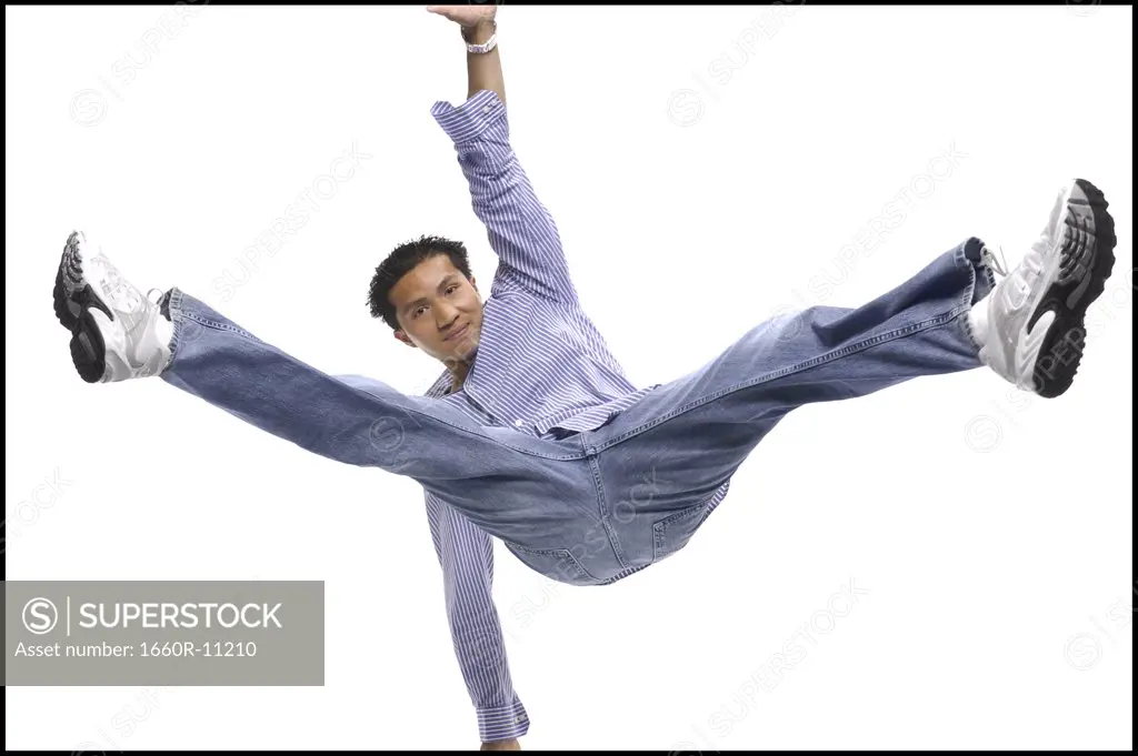 Portrait of a teenage boy jumping with legs stretched out