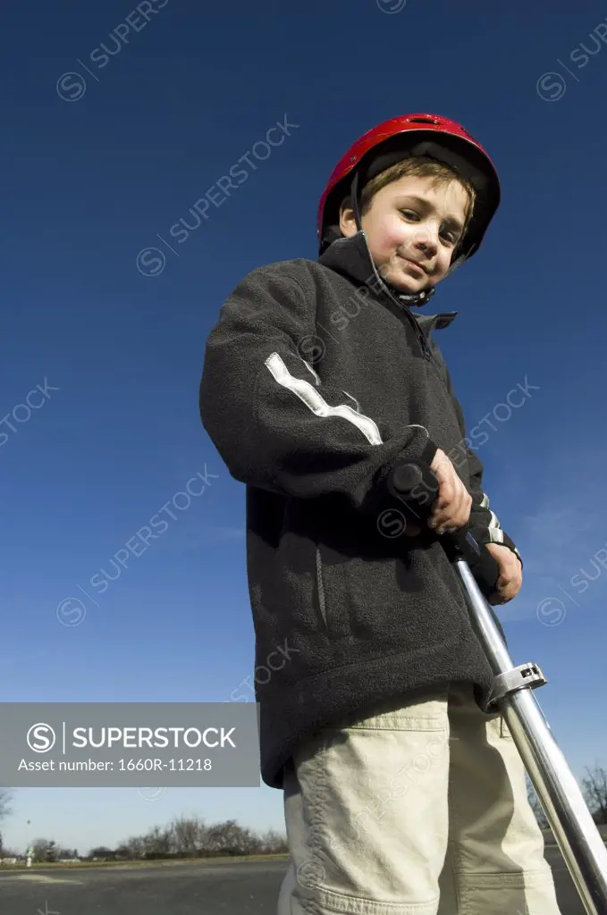 Portrait of a boy holding a push scooter