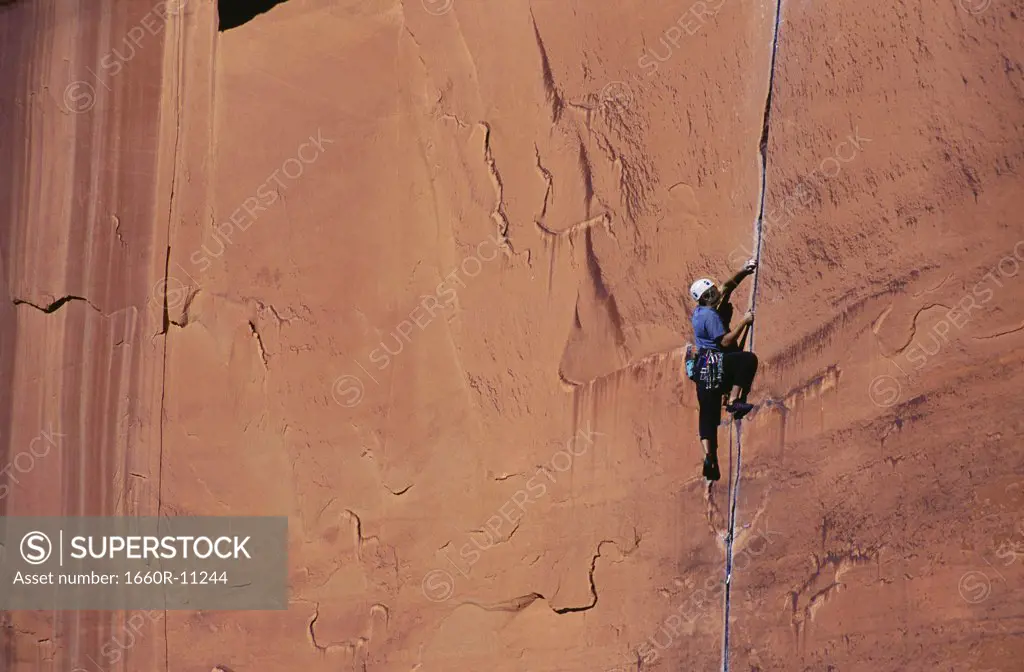 Low angle view of a woman climbing on a rock