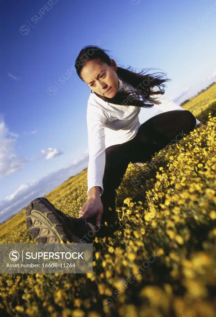 Young woman stretching on a field
