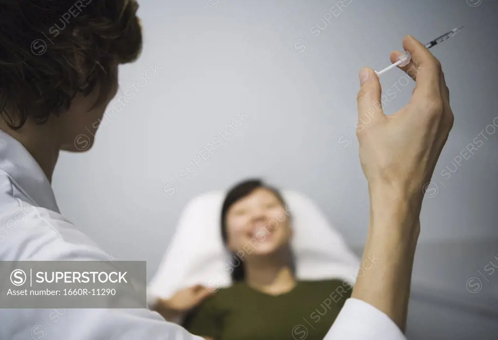 Female doctor standing holding botox injection
