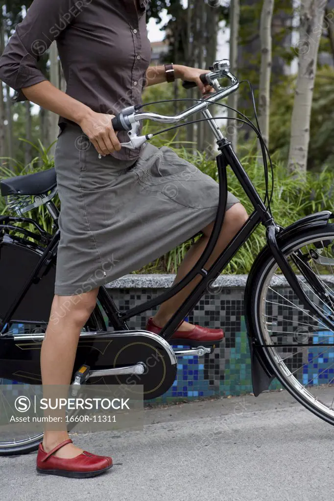 Low angle view of a woman holding a bicycle