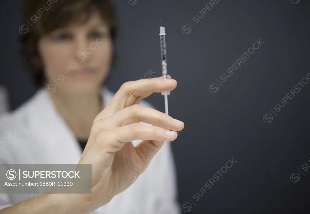 Close-up of a female doctor holding an injection