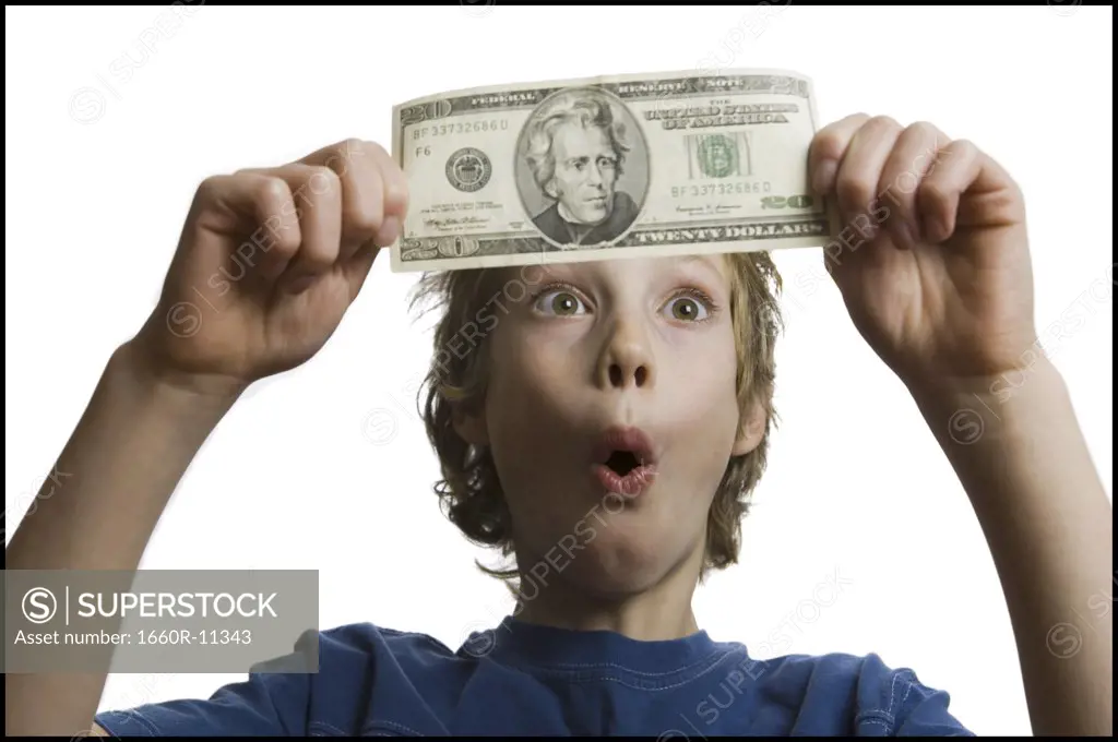 Close-up of a boy looking at a twenty dollar bill