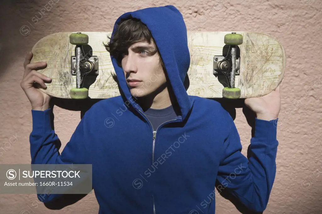 Close-up of a teenage boy holding a skateboard
