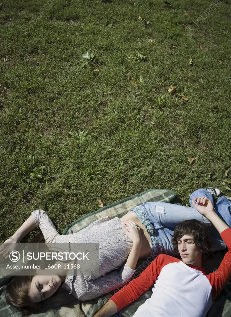 Teenage couple lying in the park