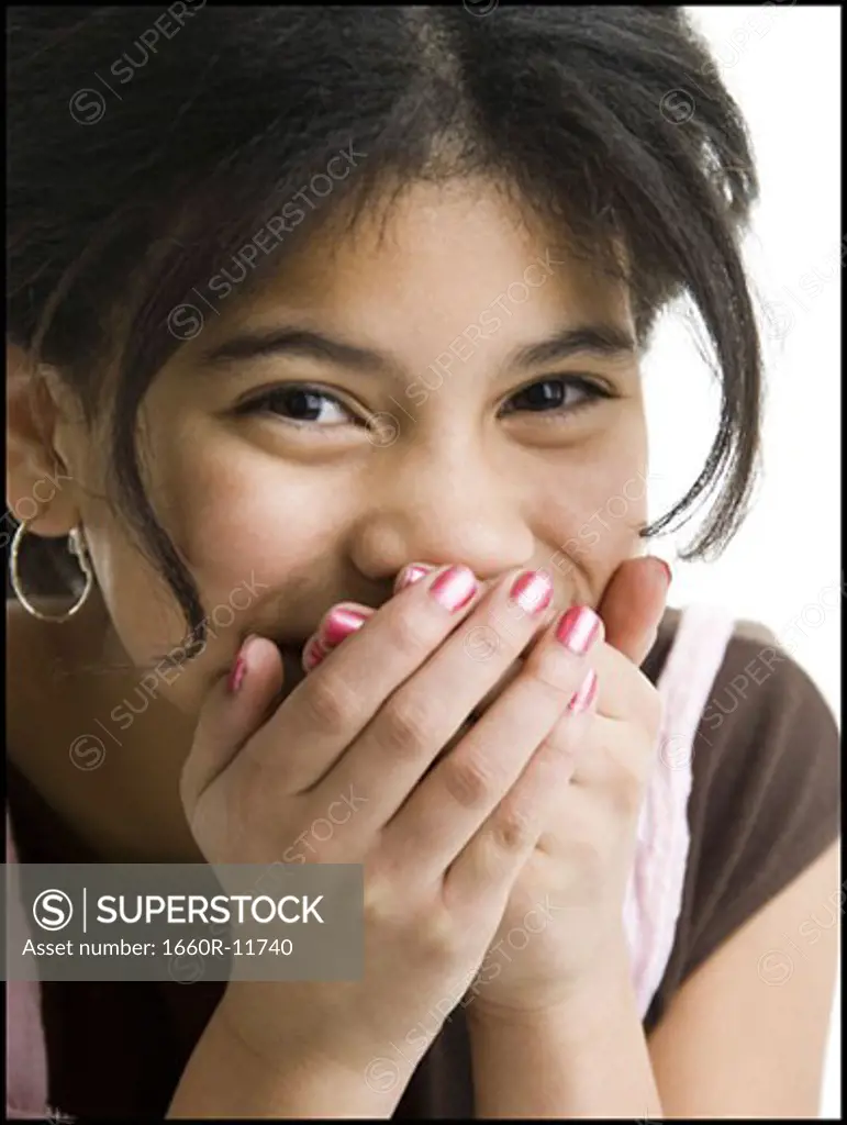 Portrait of a girl covering her mouth with her hands