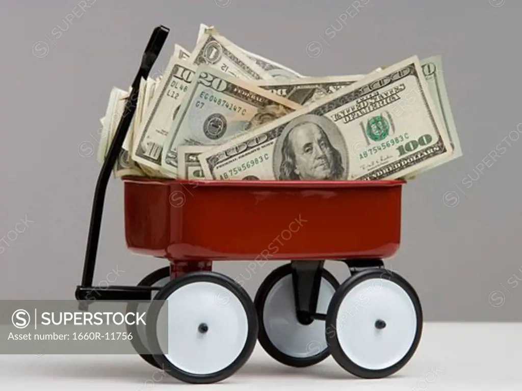 Close-up of dollar bills in a toy wagon