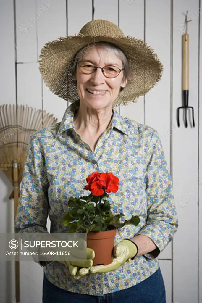 Portrait of an elderly woman holding a potted plant
