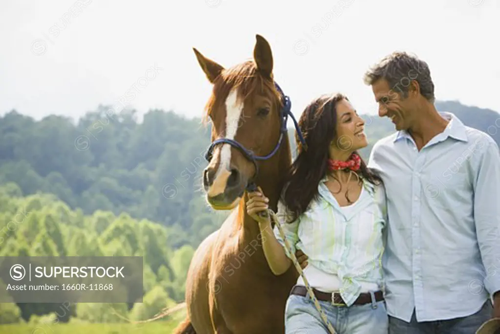 A Man and a woman standing with a horse