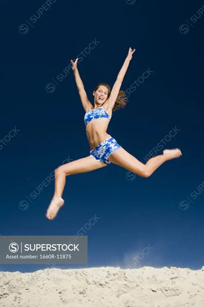 A young woman jumping at the beach
