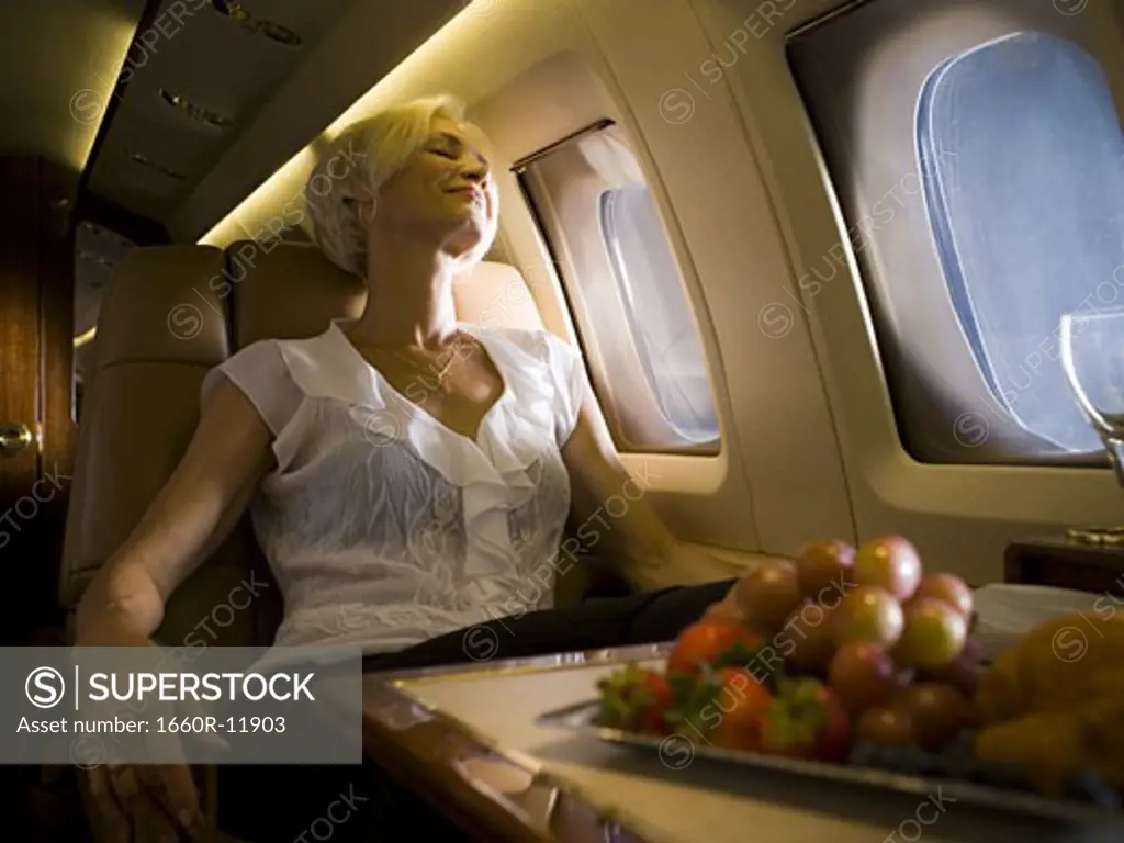 A senior woman sleeping in an airplane