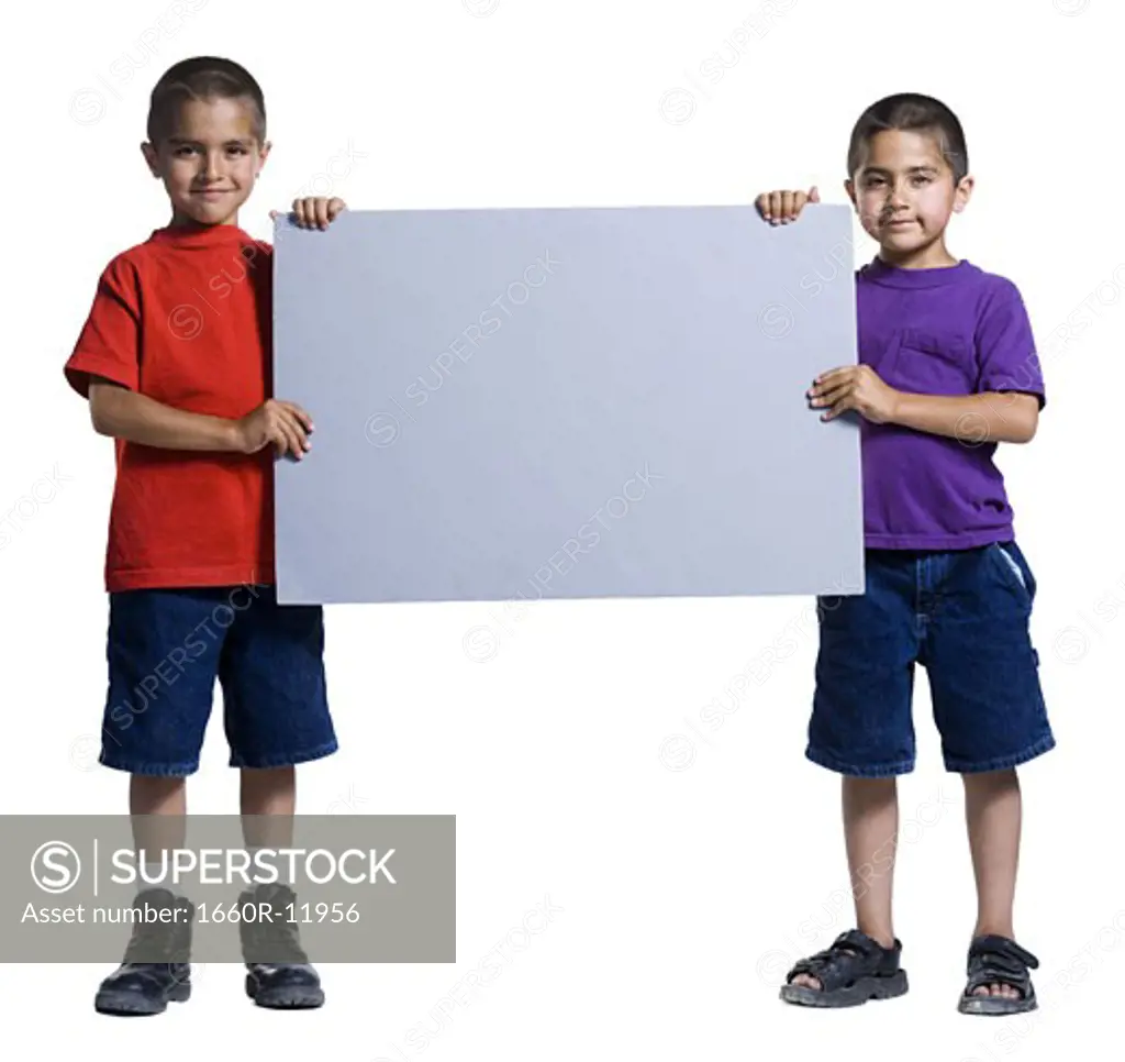 Two young brothers holding a blank sign