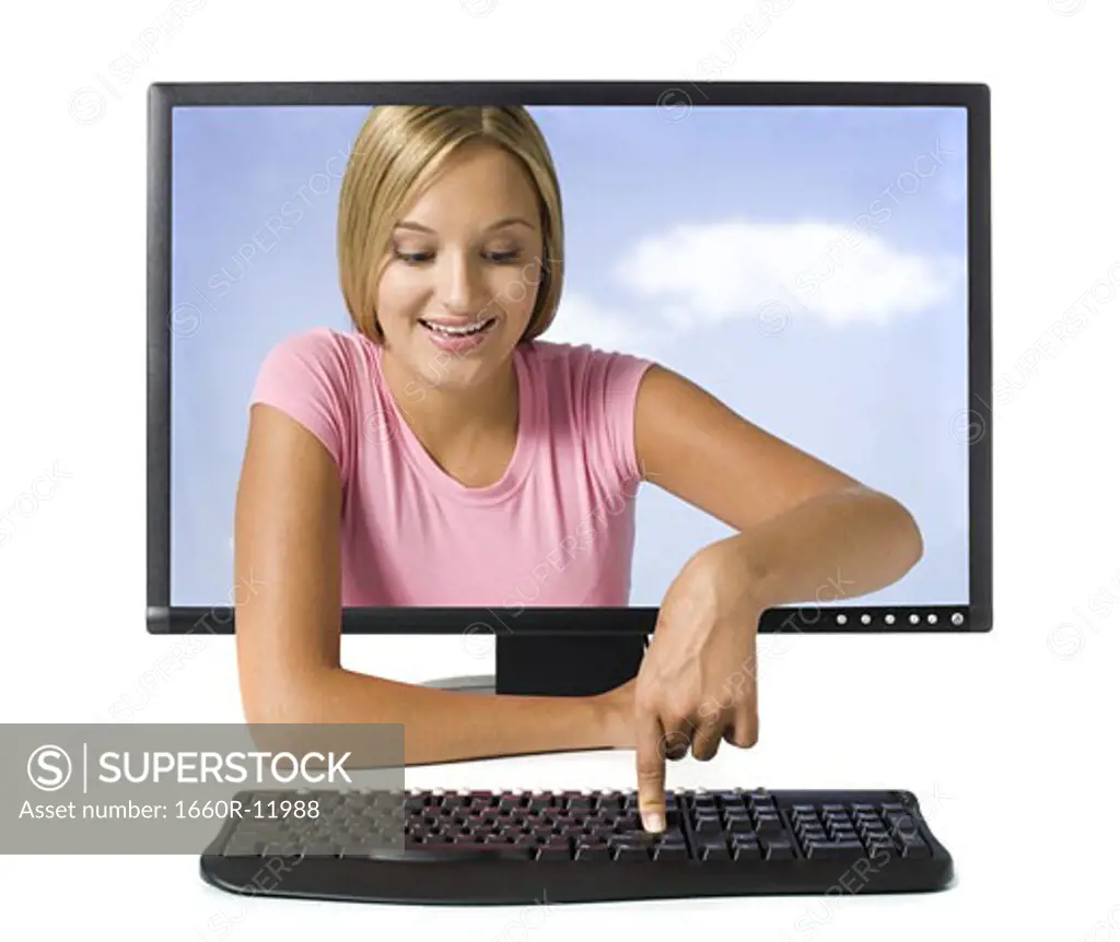 Young woman in desktop computer monitor pressing button on keyboard