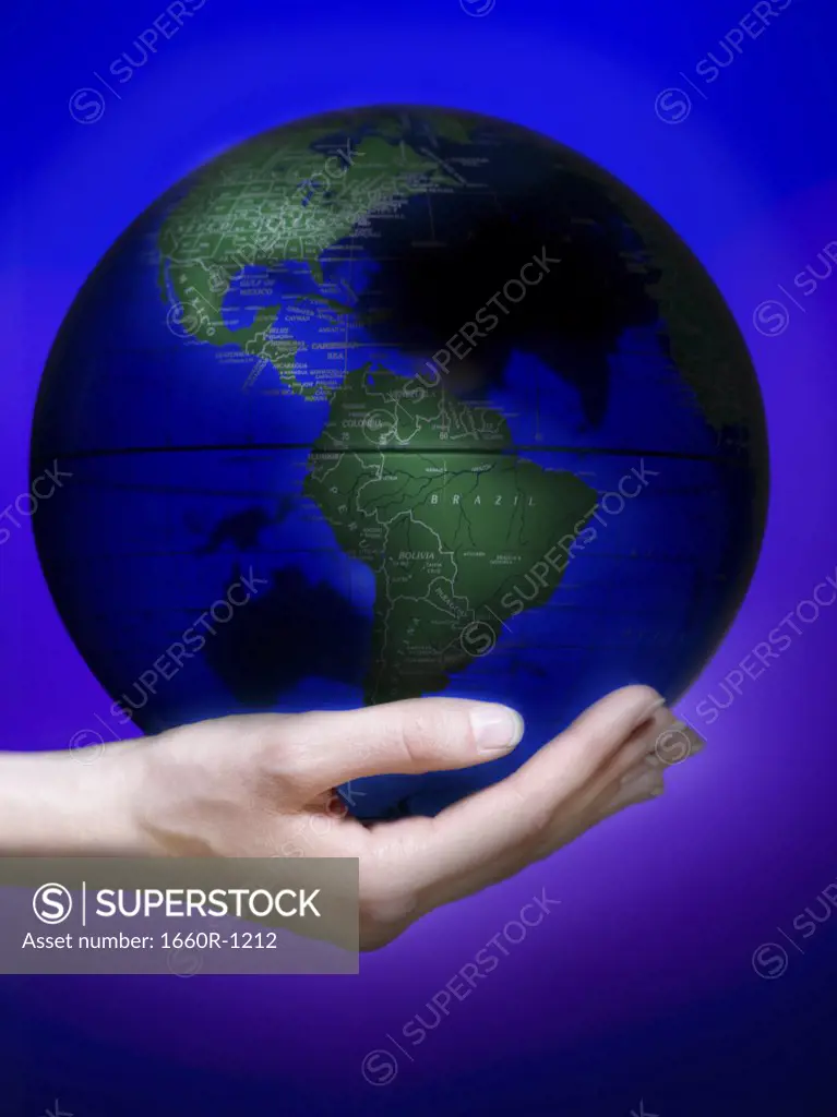 Close-up of a human hand holding a globe