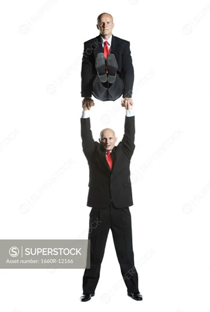 Portrait of two male acrobats in business suits performing