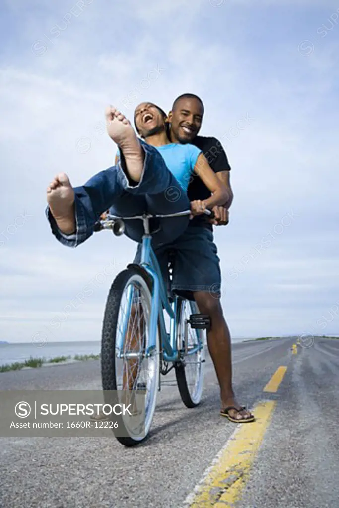 Low angle view of a young couple sitting on a bicycle