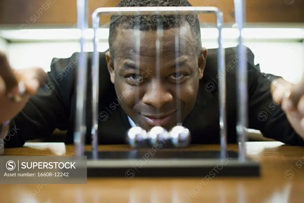 Portrait of a businessman looking at a pendulum and smiling