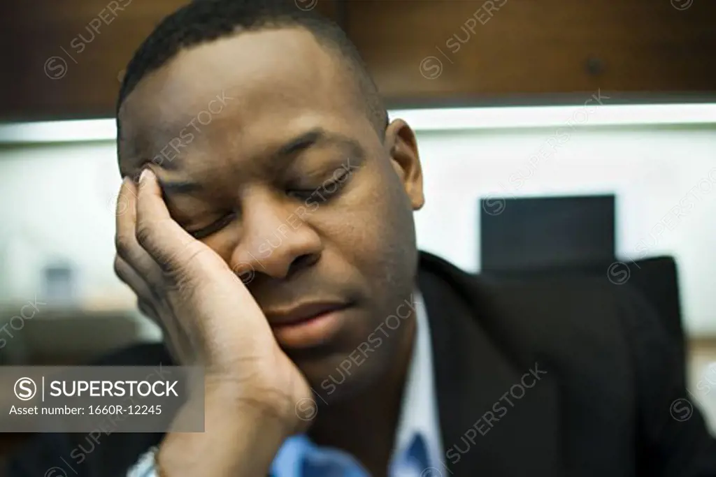 Close-up of a businessman sleeping with his head in his hands