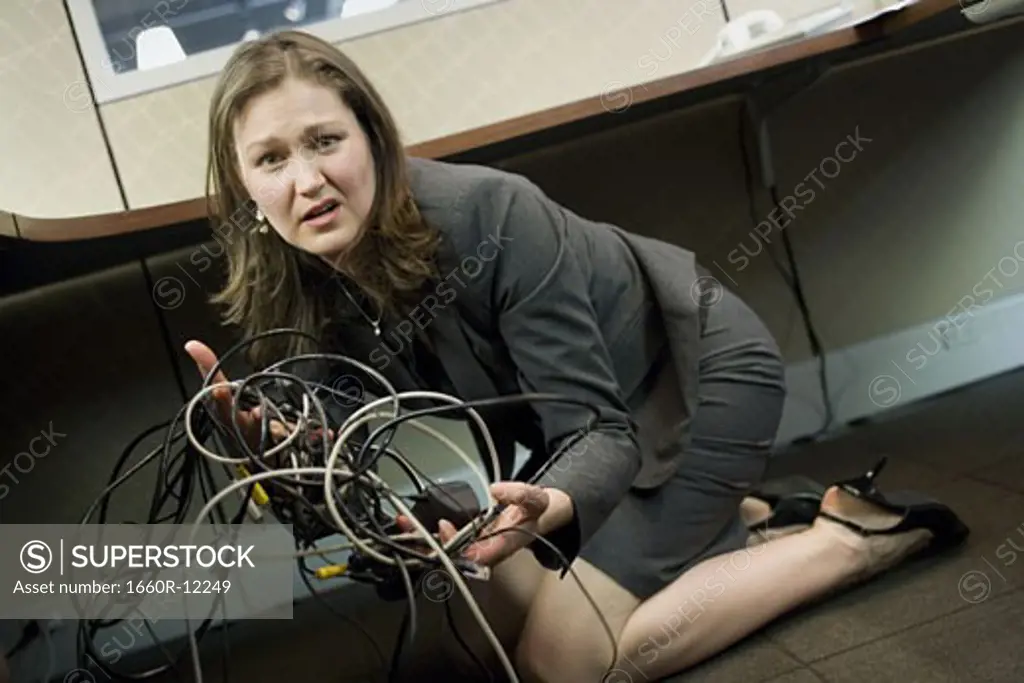 Portrait of a businesswoman holding tangled wires