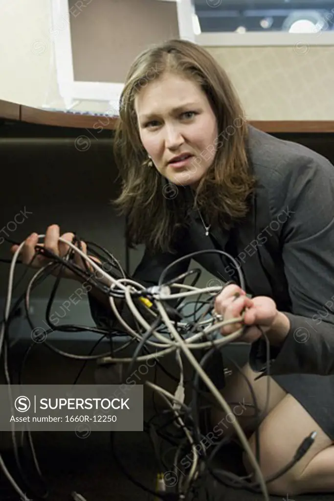 Portrait of a businesswoman holding tangled wires