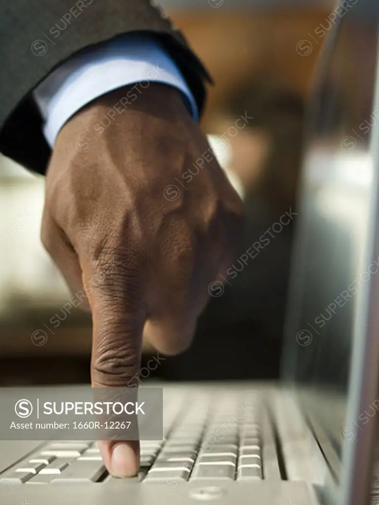 Close-up of a man's hand using a laptop