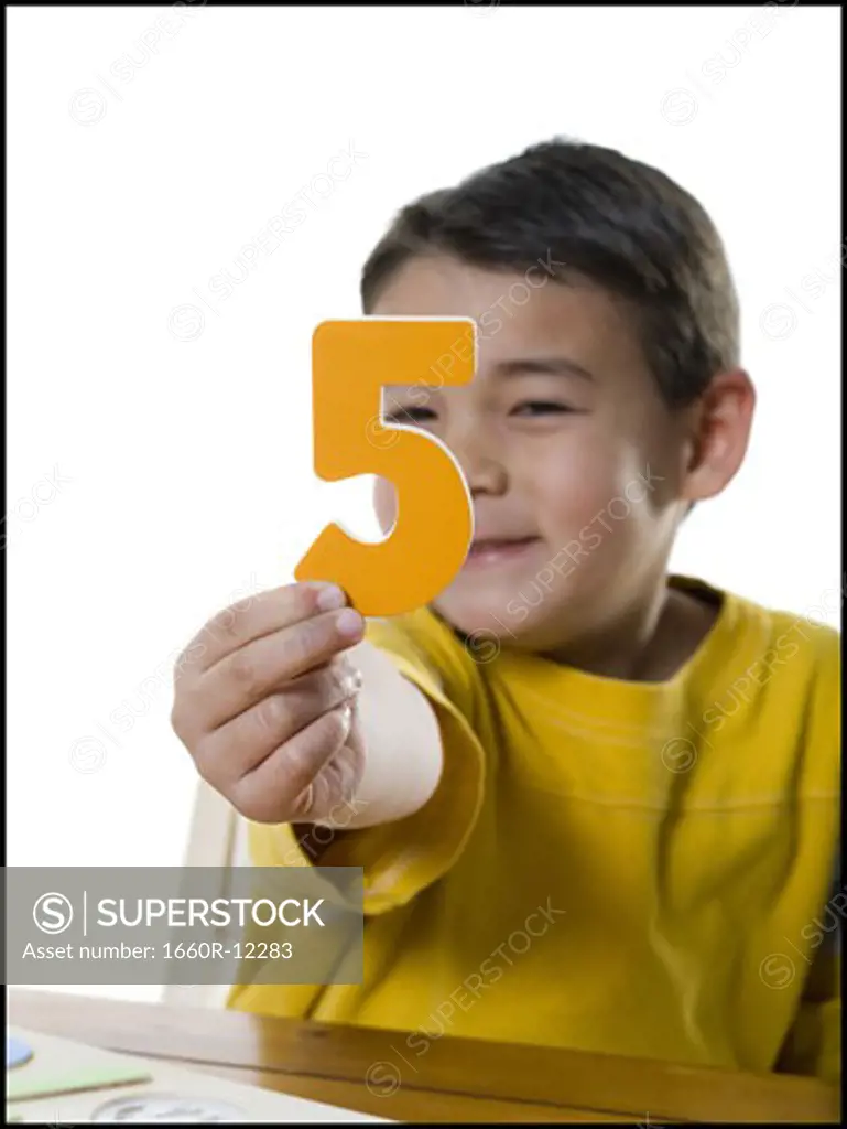 Portrait of a boy holding a number