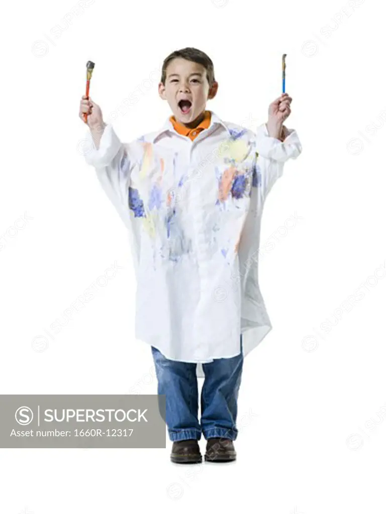 Portrait of a boy holding two paintbrushes
