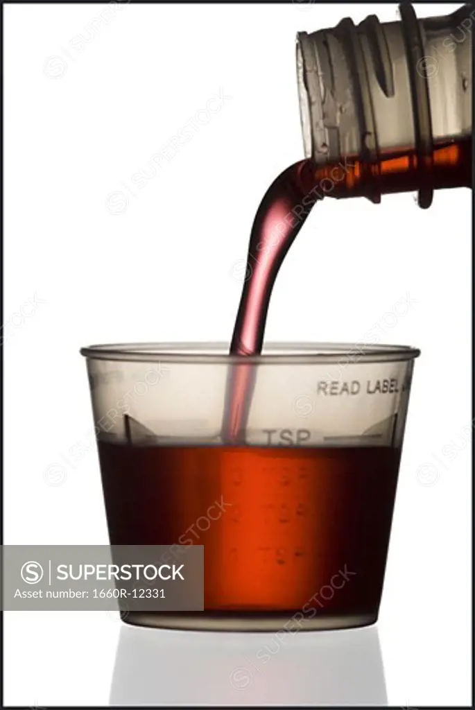 Syrup being poured into a plastic measuring cup