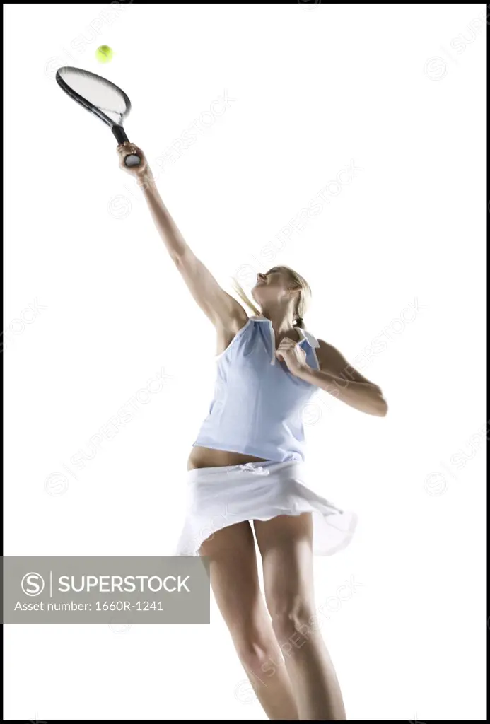 Low angle view of a young woman playing tennis