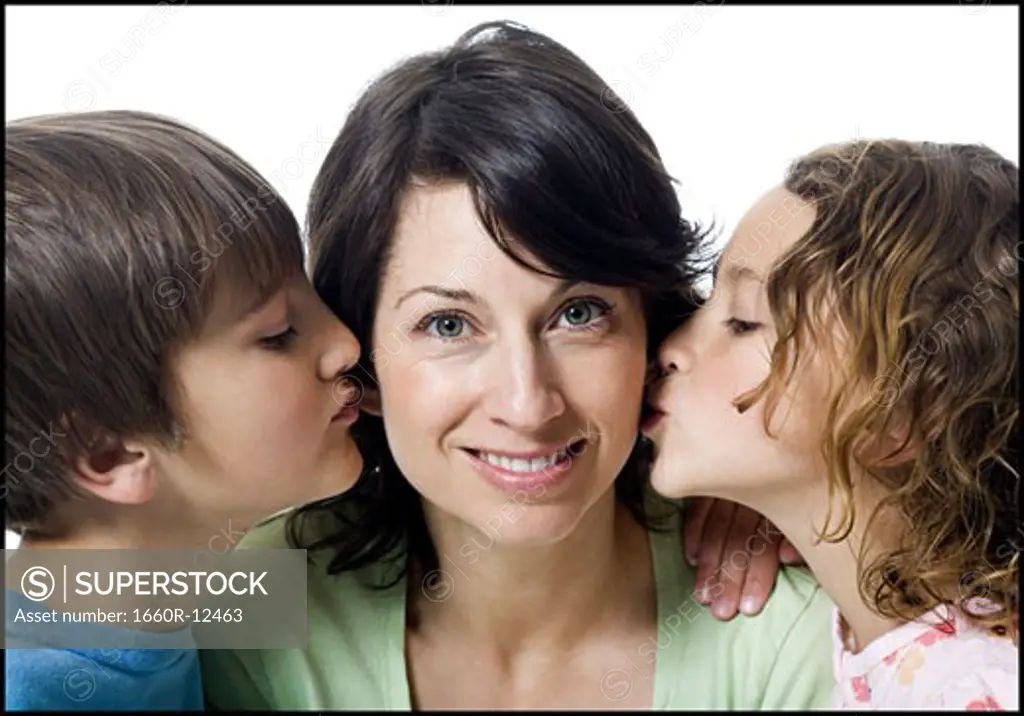 Close-up of a girl and a boy kissing their mother