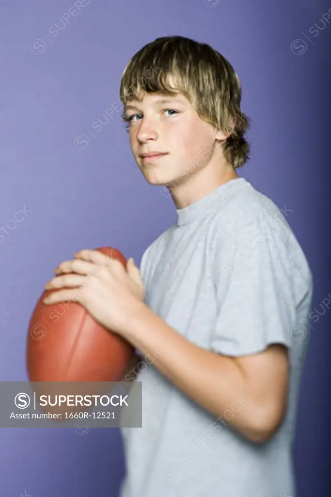 Portrait of a teenage boy holding a rugby ball