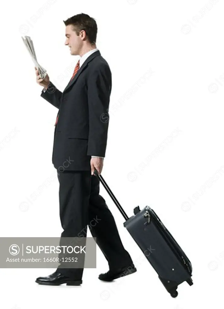 Profile of a businessman walking with luggage