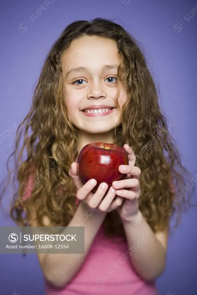 Portrait of a girl holding an apple