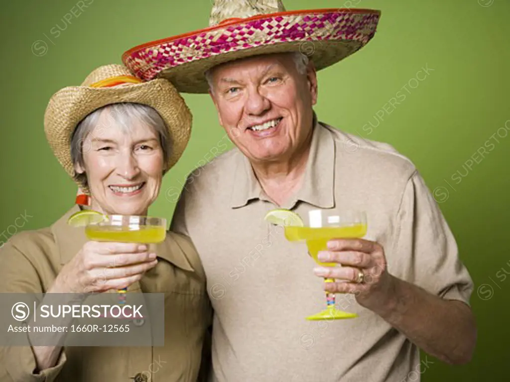 Portrait of an elderly couple holding glasses of lemon juice