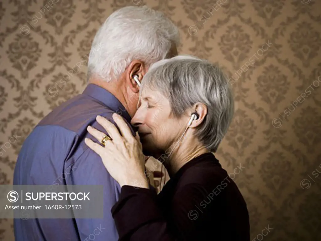Profile of an elderly couple dancing and listening to music